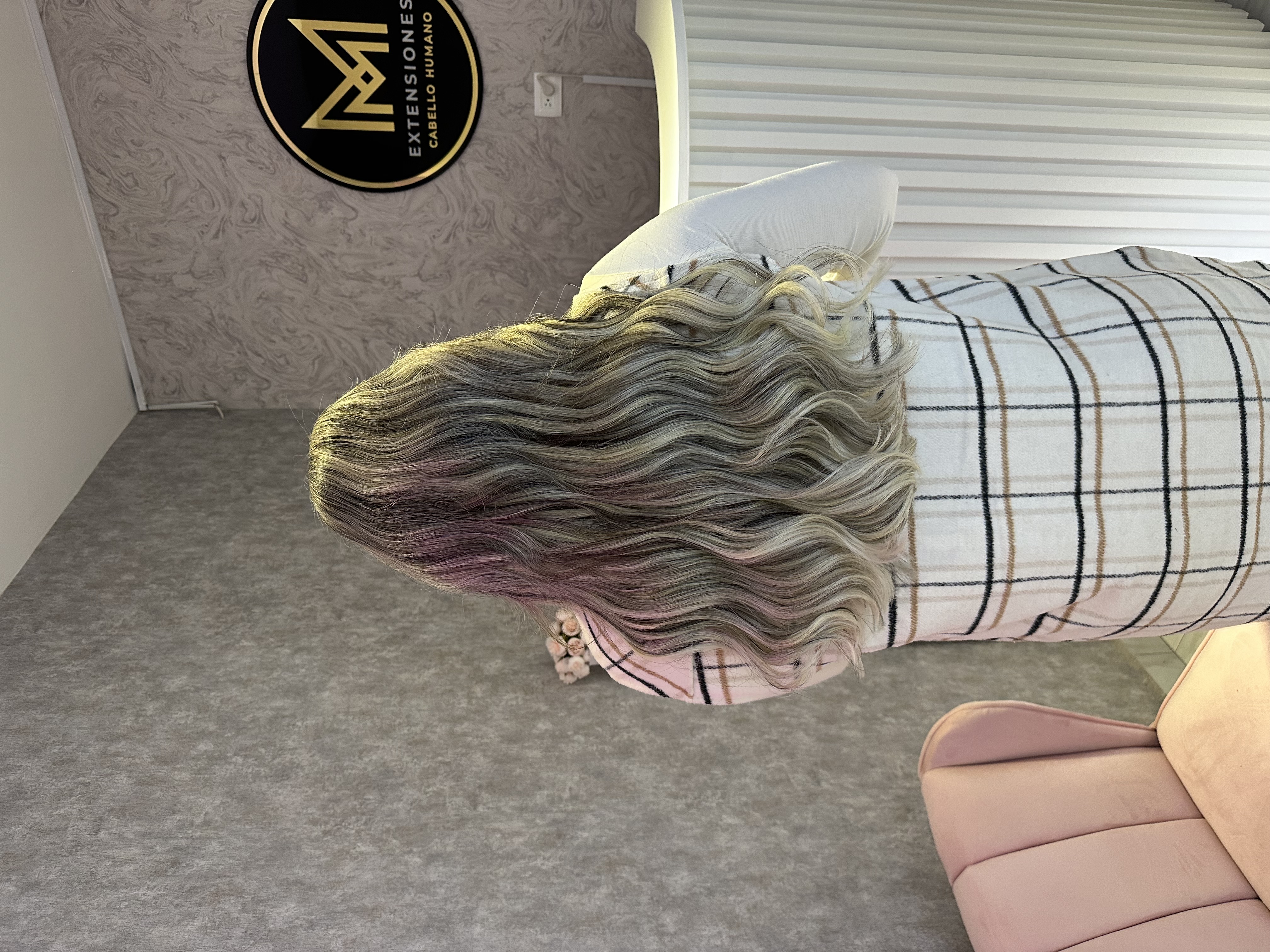 Mujer estilizando cabello con extensiones que soportan calor